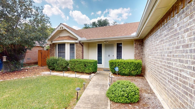 property entrance with a lawn