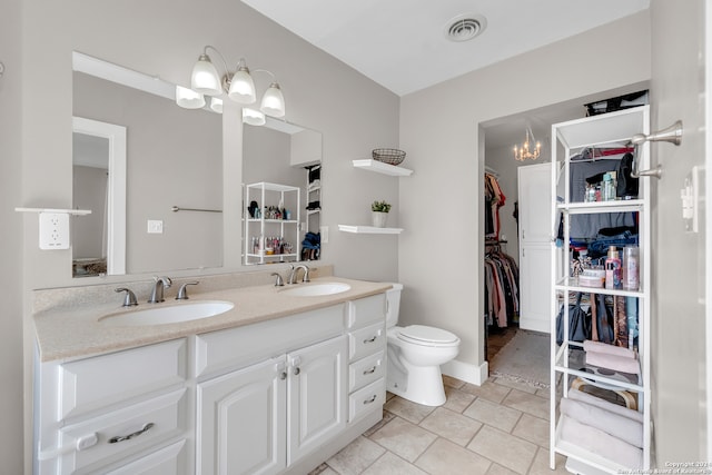 bathroom with vanity, a chandelier, toilet, and tile patterned flooring