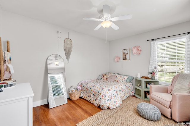 bedroom featuring multiple windows, hardwood / wood-style flooring, and ceiling fan