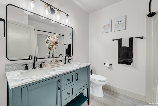 bathroom featuring walk in shower, wood-type flooring, vanity, and toilet