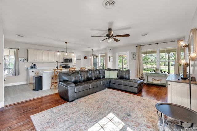 living room with ceiling fan, dark hardwood / wood-style floors, and sink