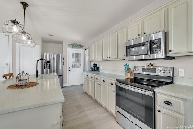 kitchen featuring light stone counters, sink, a center island with sink, appliances with stainless steel finishes, and decorative light fixtures