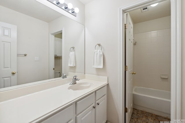 bathroom with tiled shower / bath combo and vanity