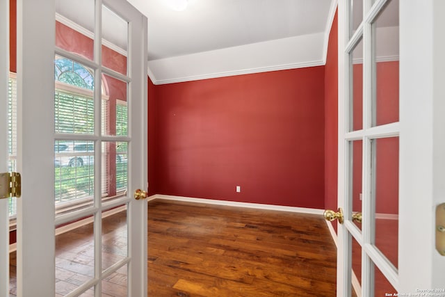 empty room with hardwood / wood-style flooring and crown molding