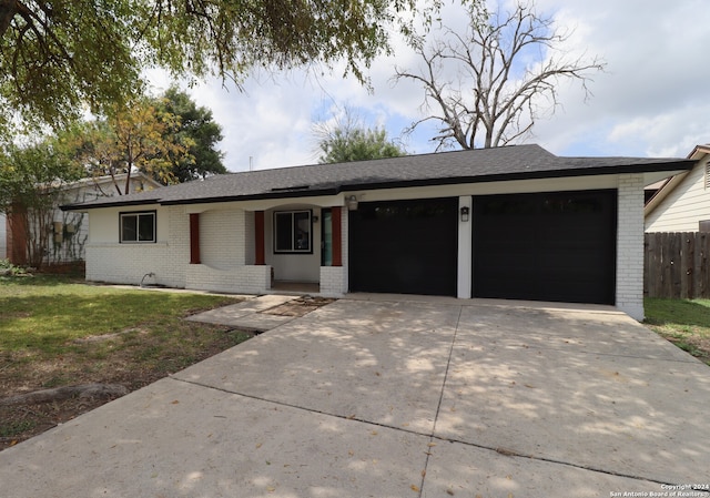 ranch-style home featuring a front yard, a garage, and covered porch