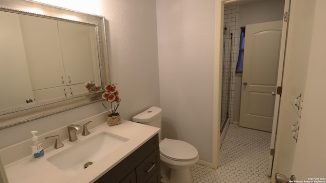 bathroom featuring walk in shower, vanity, toilet, and tile patterned floors