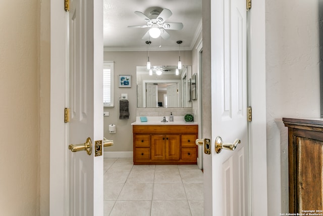 bathroom with ceiling fan, vanity, ornamental molding, tasteful backsplash, and tile patterned floors