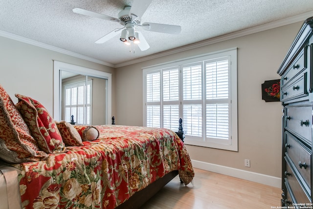 bedroom featuring light wood-type flooring, crown molding, a textured ceiling, and ceiling fan