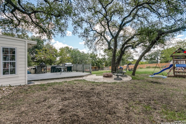 view of yard with a playground, a fire pit, and a patio