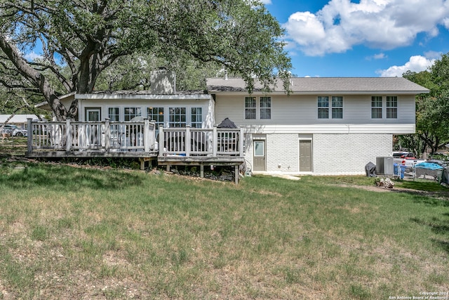 back of house featuring central AC unit, a wooden deck, and a lawn