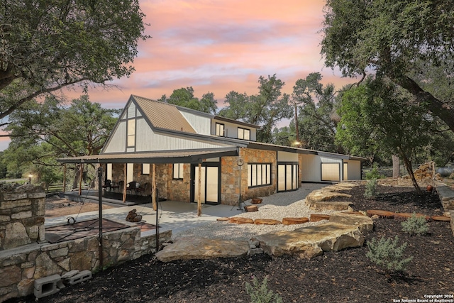 back house at dusk featuring a patio