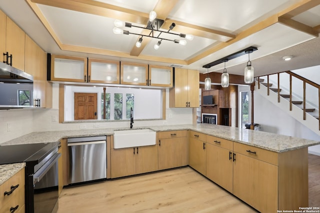 kitchen with appliances with stainless steel finishes, kitchen peninsula, light brown cabinets, and light hardwood / wood-style flooring