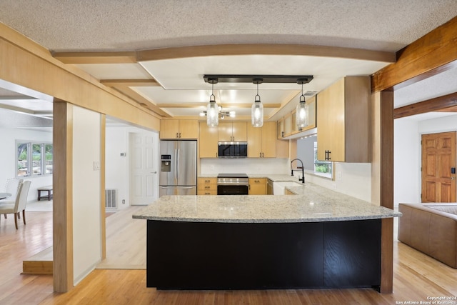 kitchen featuring light brown cabinetry, pendant lighting, appliances with stainless steel finishes, and a wealth of natural light