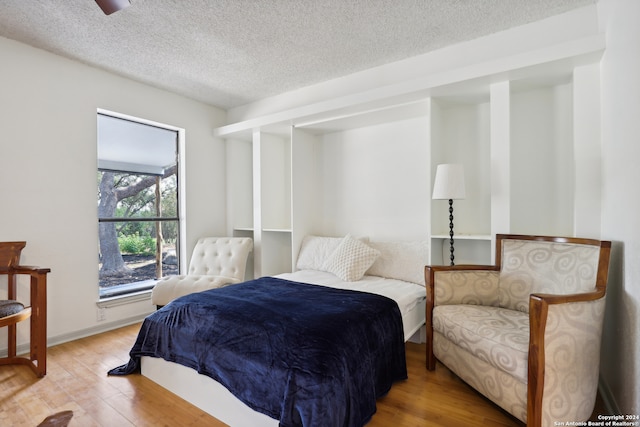 bedroom featuring a textured ceiling and hardwood / wood-style flooring