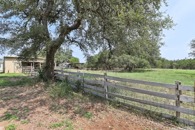 view of yard with an outdoor structure and a rural view