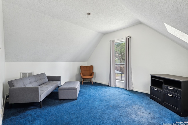 sitting room featuring dark carpet, a textured ceiling, and vaulted ceiling with skylight