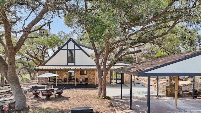 rear view of property featuring a gazebo and a patio area