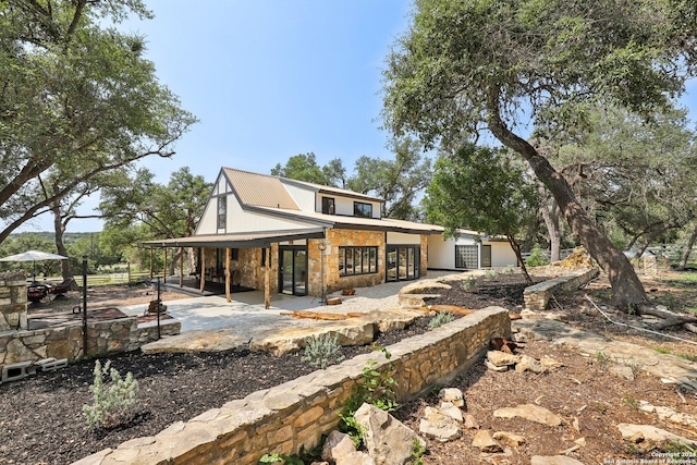 back of property featuring a patio and a fire pit