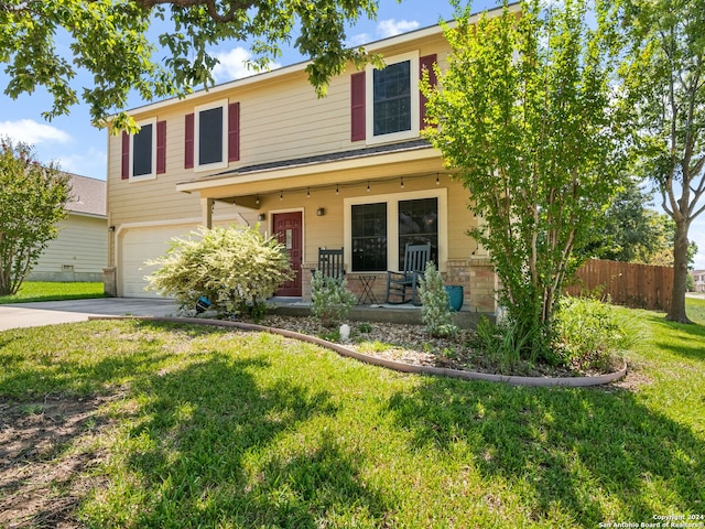 view of front of home featuring a front lawn, covered porch, and a garage