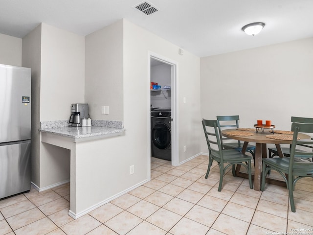 dining space featuring washer / dryer and light tile patterned floors