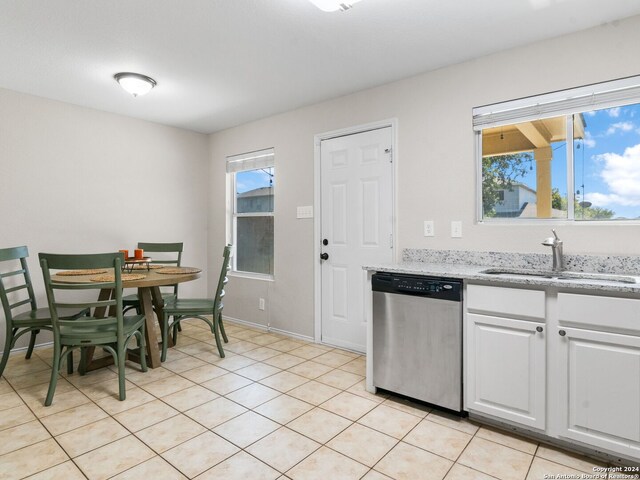 kitchen featuring light tile patterned floors, sink, white cabinetry, and stainless steel dishwasher