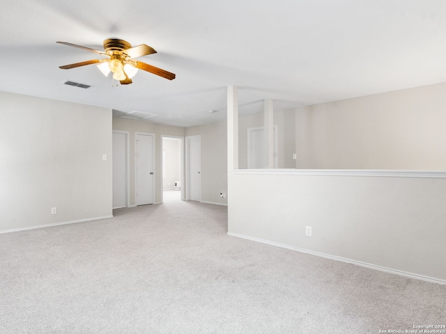 spare room with ceiling fan and light colored carpet