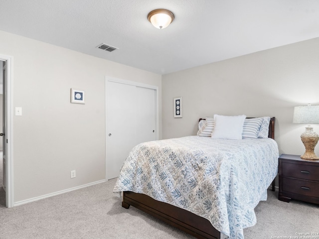 bedroom featuring light carpet and a closet