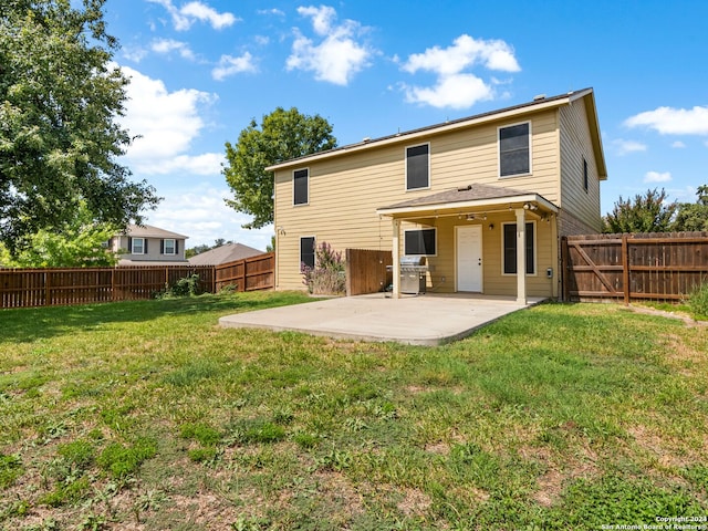 back of property with a lawn and a patio