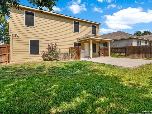 rear view of property featuring a yard and a patio area