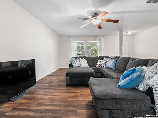 living room featuring ceiling fan and dark hardwood / wood-style flooring