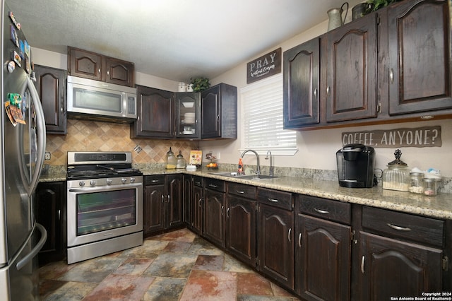 kitchen with sink, decorative backsplash, dark brown cabinetry, and stainless steel appliances