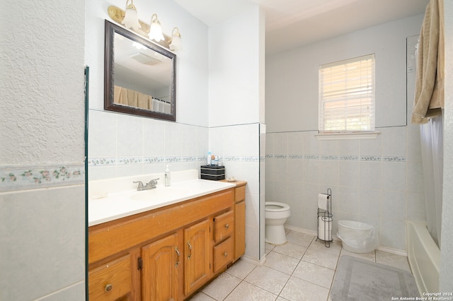 full bathroom featuring tile patterned floors, toilet, shower / tub combo, vanity, and tile walls