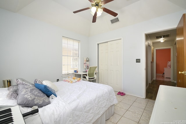 tiled bedroom featuring a closet, ceiling fan, and lofted ceiling