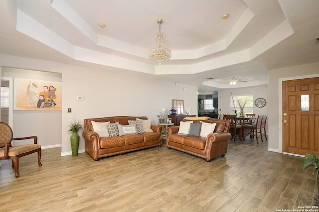 living room with light hardwood / wood-style flooring and a raised ceiling