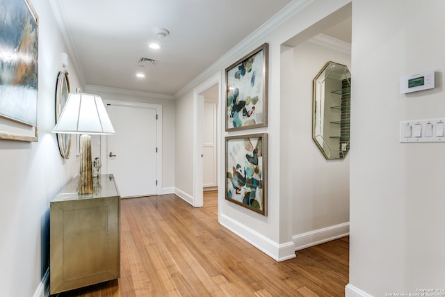 hallway featuring crown molding and light hardwood / wood-style floors