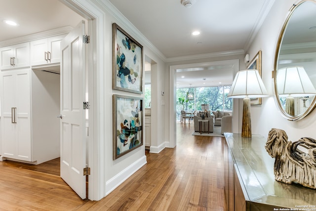 corridor featuring ornamental molding and light wood-type flooring