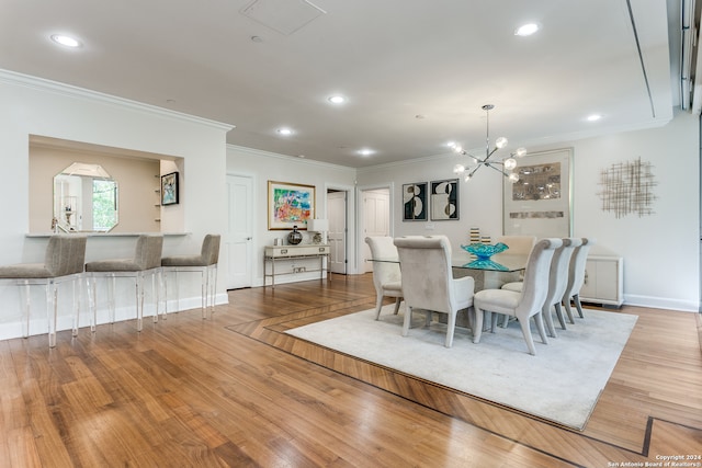 dining space featuring an inviting chandelier, light wood-type flooring, and crown molding