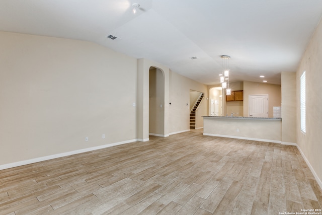 unfurnished living room with light hardwood / wood-style flooring and vaulted ceiling