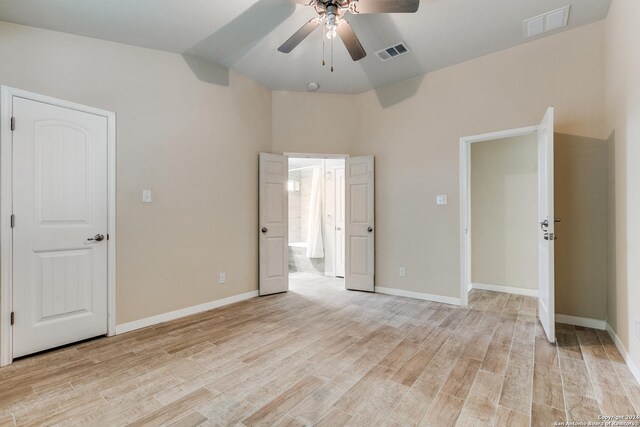 unfurnished bedroom with ceiling fan, vaulted ceiling, and light hardwood / wood-style floors