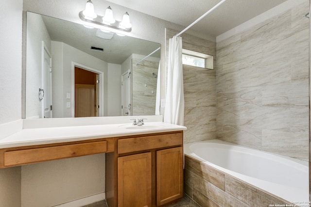 bathroom with shower / tub combo with curtain, a textured ceiling, and vanity