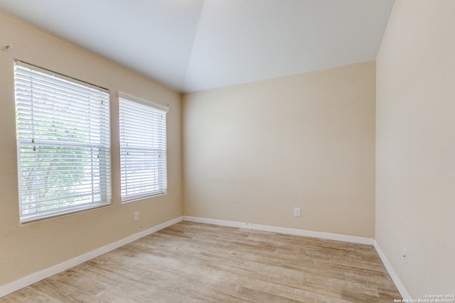 unfurnished room with lofted ceiling and light hardwood / wood-style flooring