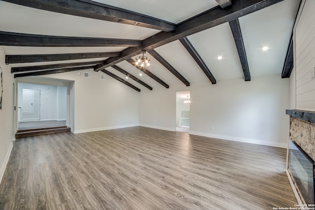 unfurnished living room featuring a notable chandelier, hardwood / wood-style floors, lofted ceiling with beams, and a fireplace