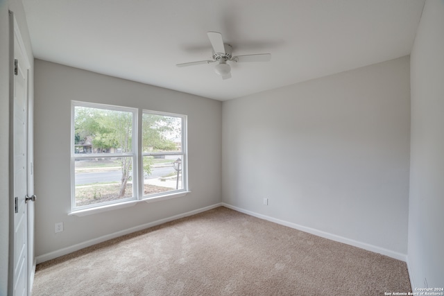 spare room featuring ceiling fan and light colored carpet