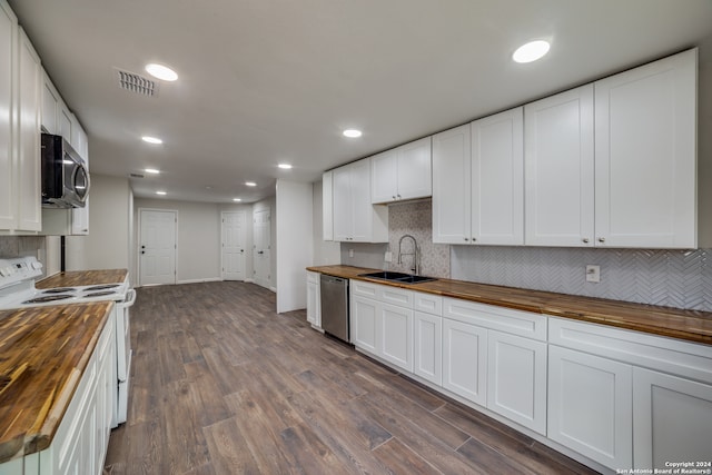 kitchen with white cabinets, appliances with stainless steel finishes, sink, and wood counters