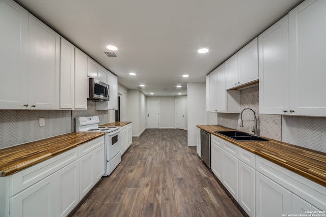 kitchen featuring white cabinets, sink, appliances with stainless steel finishes, dark hardwood / wood-style flooring, and wood counters