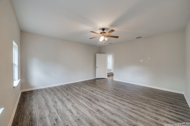 empty room with ceiling fan and dark hardwood / wood-style flooring