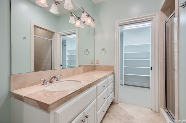 bathroom featuring an enclosed shower, vanity, and a chandelier