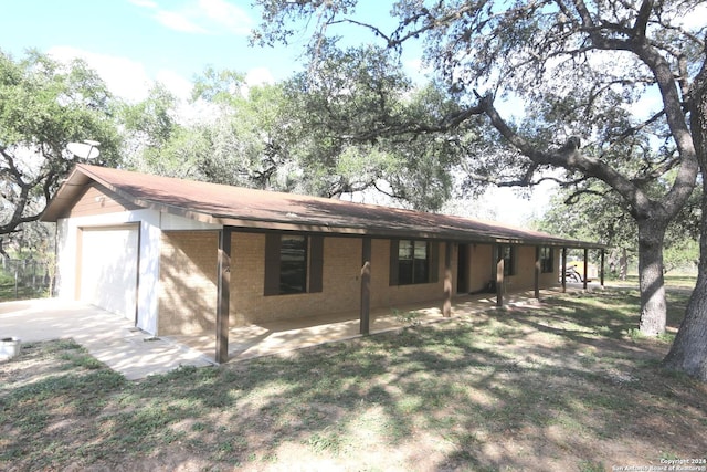 rear view of property featuring a garage and a patio