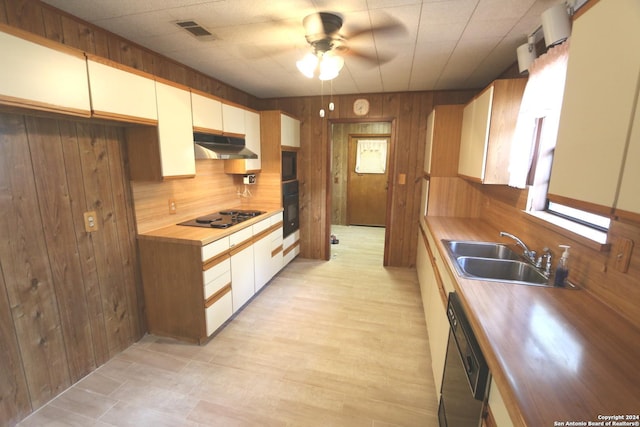 kitchen with wooden walls, sink, wooden counters, and black appliances