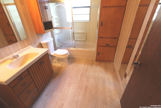 full bathroom with wood-type flooring, shower / bathing tub combination, vanity, and toilet